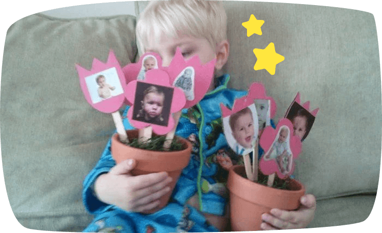 Criança segurando dois vasos de flores com fotos